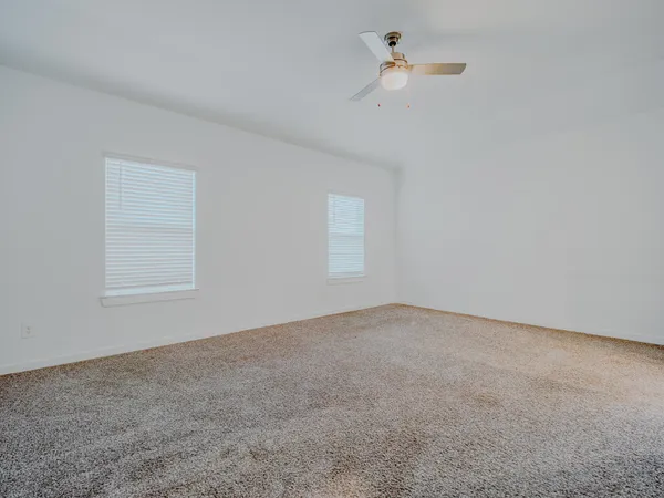 an empty room with a window and a ceiling fan