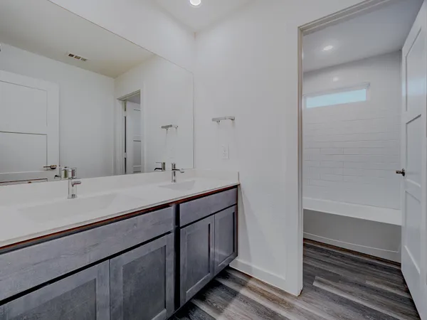 a bathroom with a tub sink and mirror