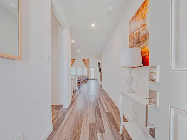 a view of a hallway with wooden floor and staircase
