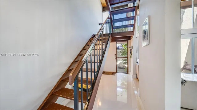 a view of staircase with lots of frames on wall and a window