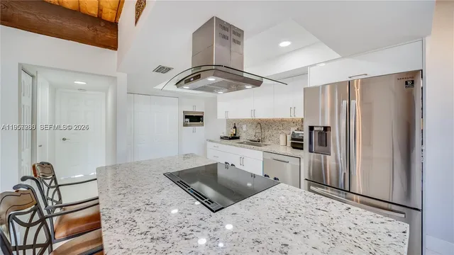 a kitchen with stainless steel appliances granite countertop a refrigerator sink and stove