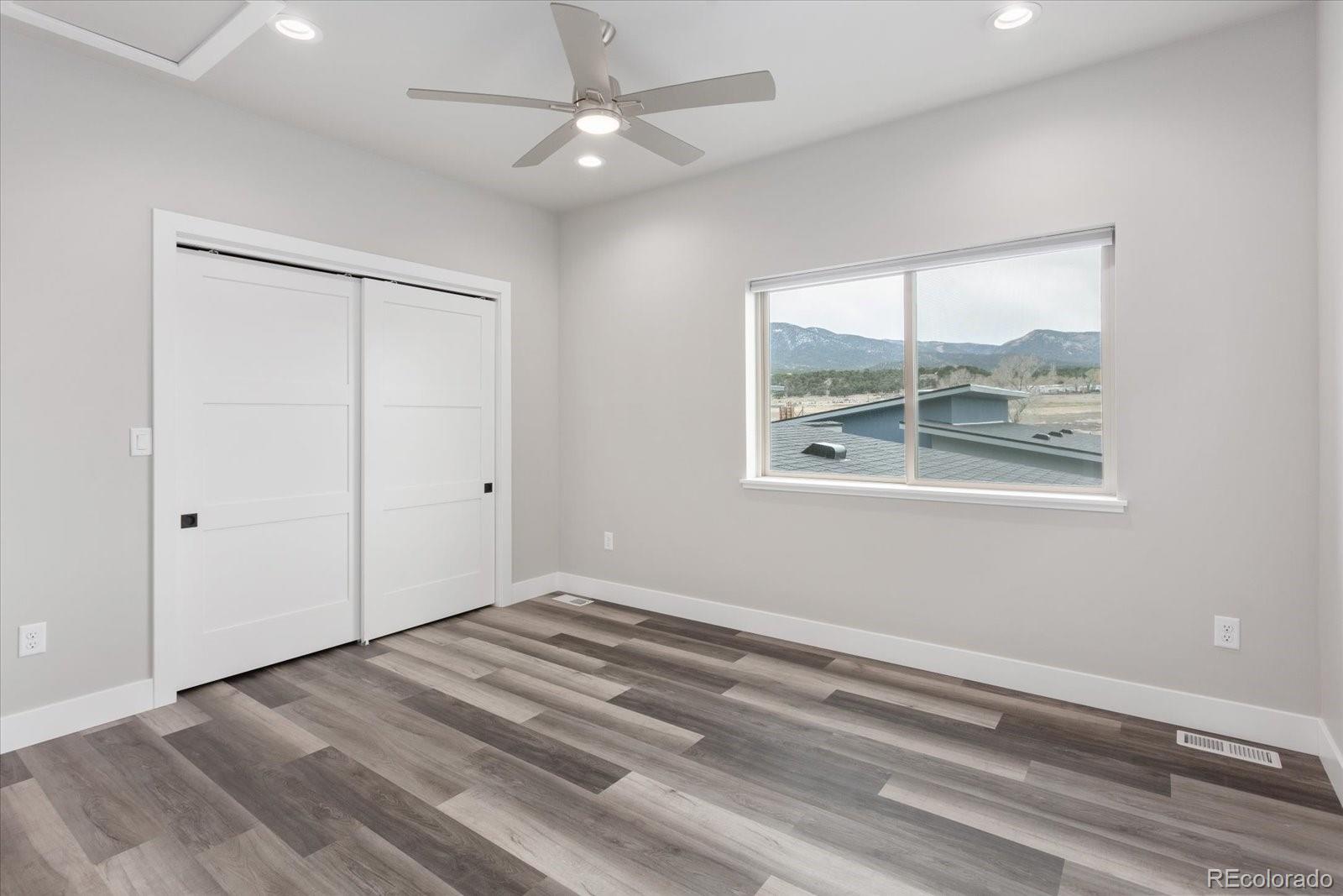 126 Southside Loop Salida, CO 81201 - Photo 18 of 29 an empty room with wooden floor chandelier and windows