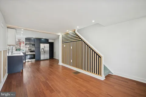 a view of a kitchen with wooden floor and electronic appliances