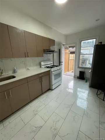 a kitchen with stainless steel appliances a stove a sink a microwave and a refrigerator