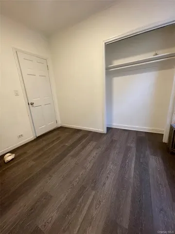 an empty room with wooden floor and door