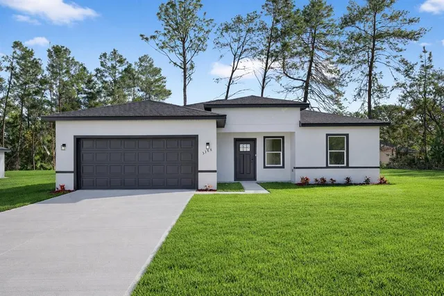a front view of a house with a garden and yard