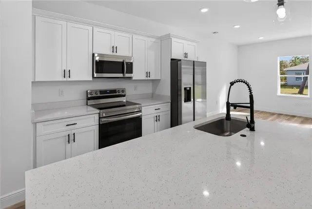 an open kitchen with wooden floor and windows
