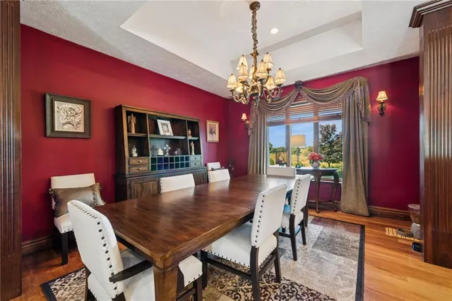 a view of a dining room with furniture a chandelier and wooden floor