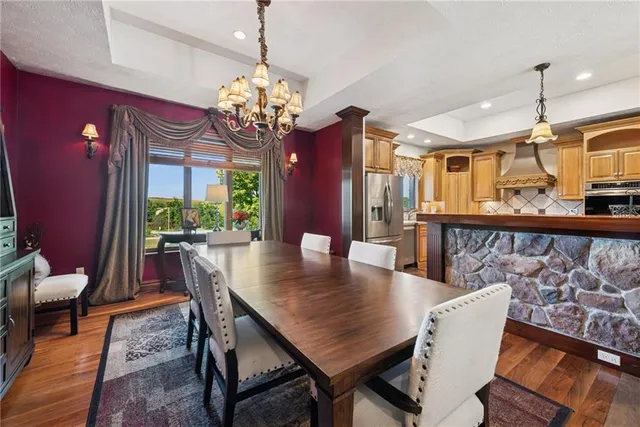 a view of a dining room with furniture a chandelier and wooden floor
