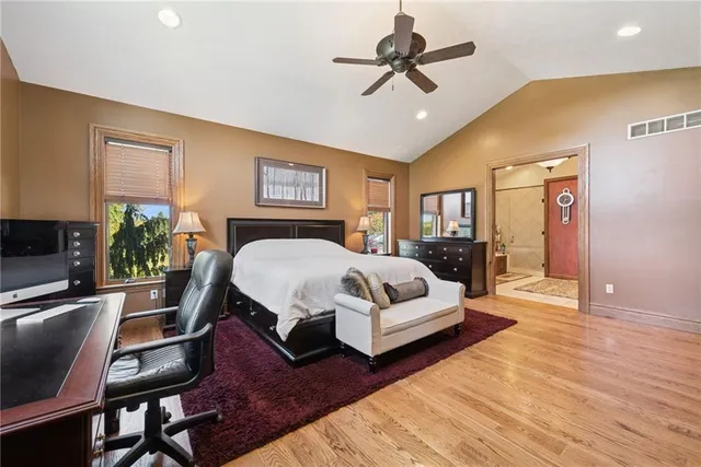 a bedroom with a bed a couch and potted plant with the dresser
