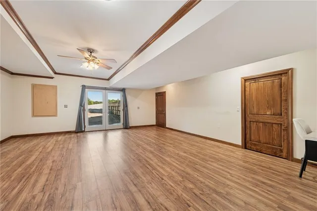 a view of empty room with wooden floor and window