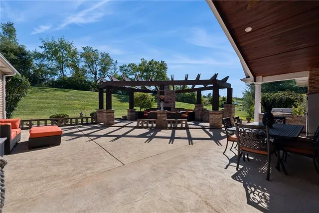 a view of a patio with swimming pool lawn chairs and a fire pit