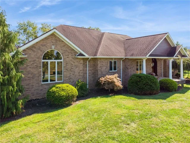 a view of a big house with a big yard and potted plants