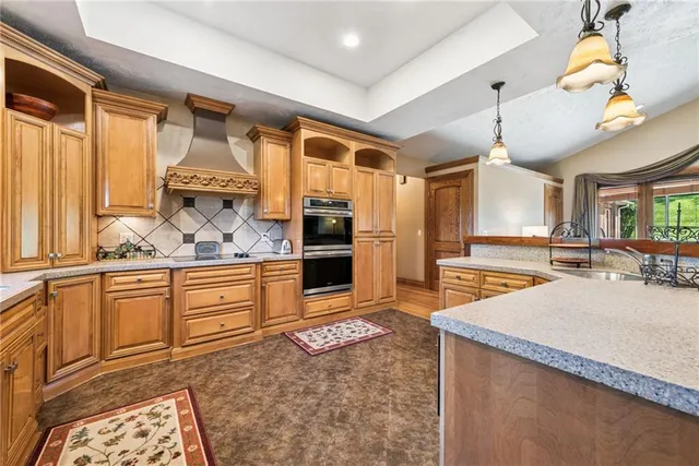 a large kitchen with kitchen island granite countertop a sink and white cabinets