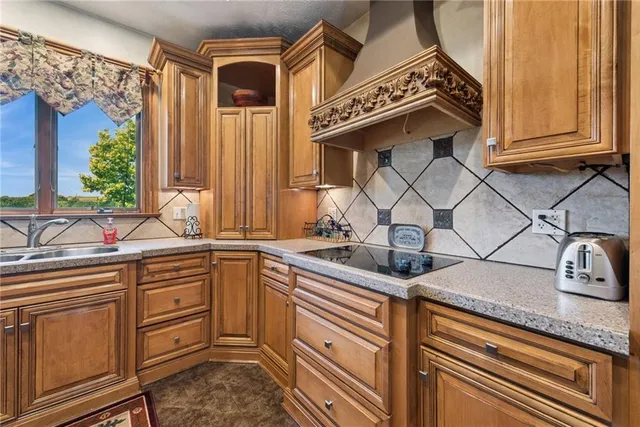a kitchen with granite countertop a sink stainless steel appliances and cabinets