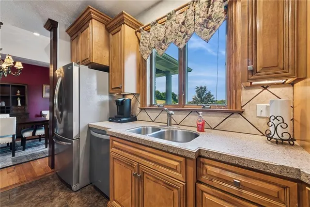 a kitchen with stainless steel appliances granite countertop a refrigerator and a sink