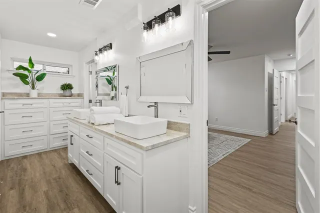 a spacious bathroom with a granite countertop sink a mirror and a shower