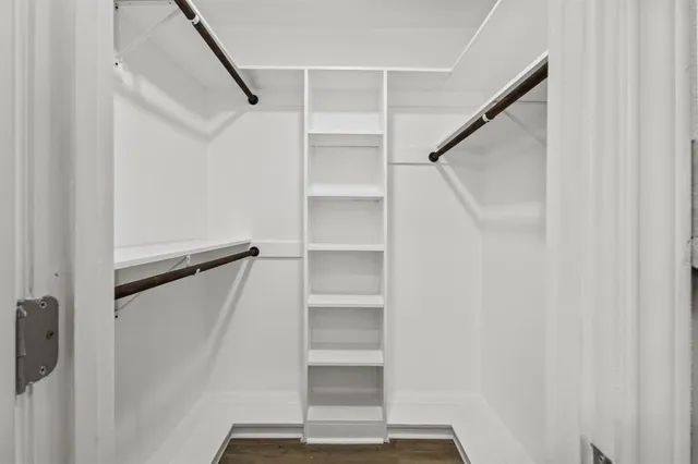 a view of walk in closet with empty racks