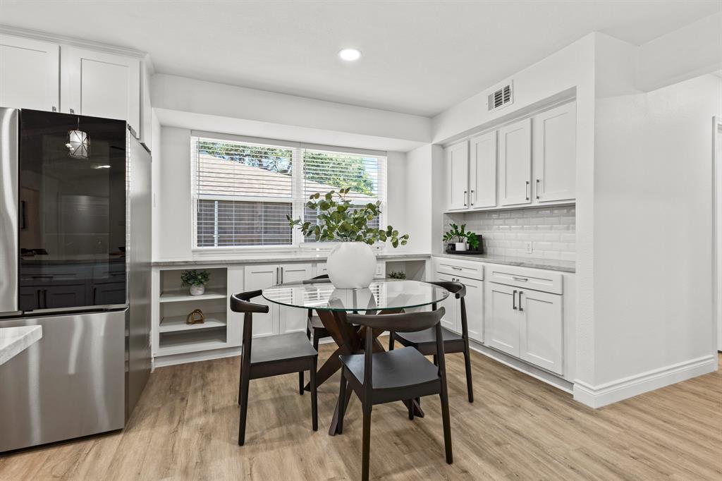4105 Candlenut Lane Dallas, TX 75244 - Photo 10 of 27 a kitchen with a table chairs refrigerator and cabinets