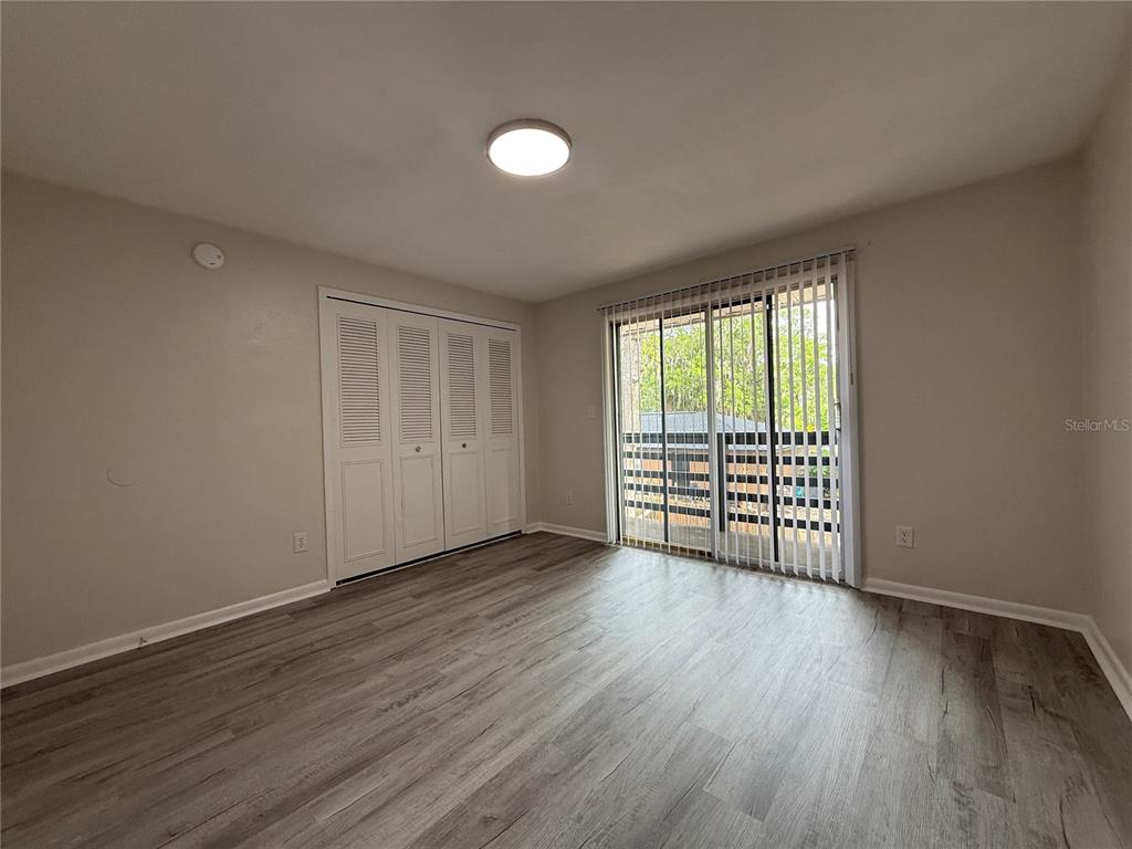 6030 Southwest 12th Place, Unit 2 Gainesville, FL 32607 - Photo 5 of 7 a view of an empty room with wooden floor and a window