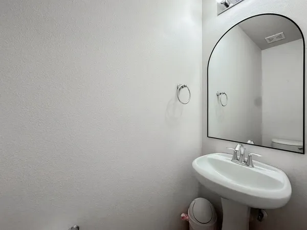 a bathroom with a sink toilet and a mirror