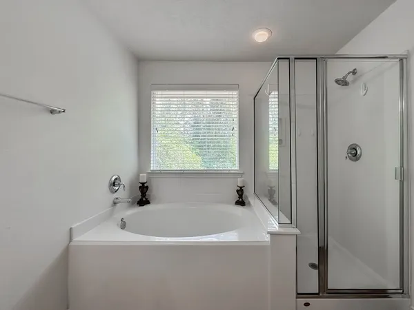 a white bath tub sitting in a bathroom next to a window