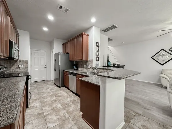 a kitchen with stainless steel appliances granite countertop a sink stove and refrigerator