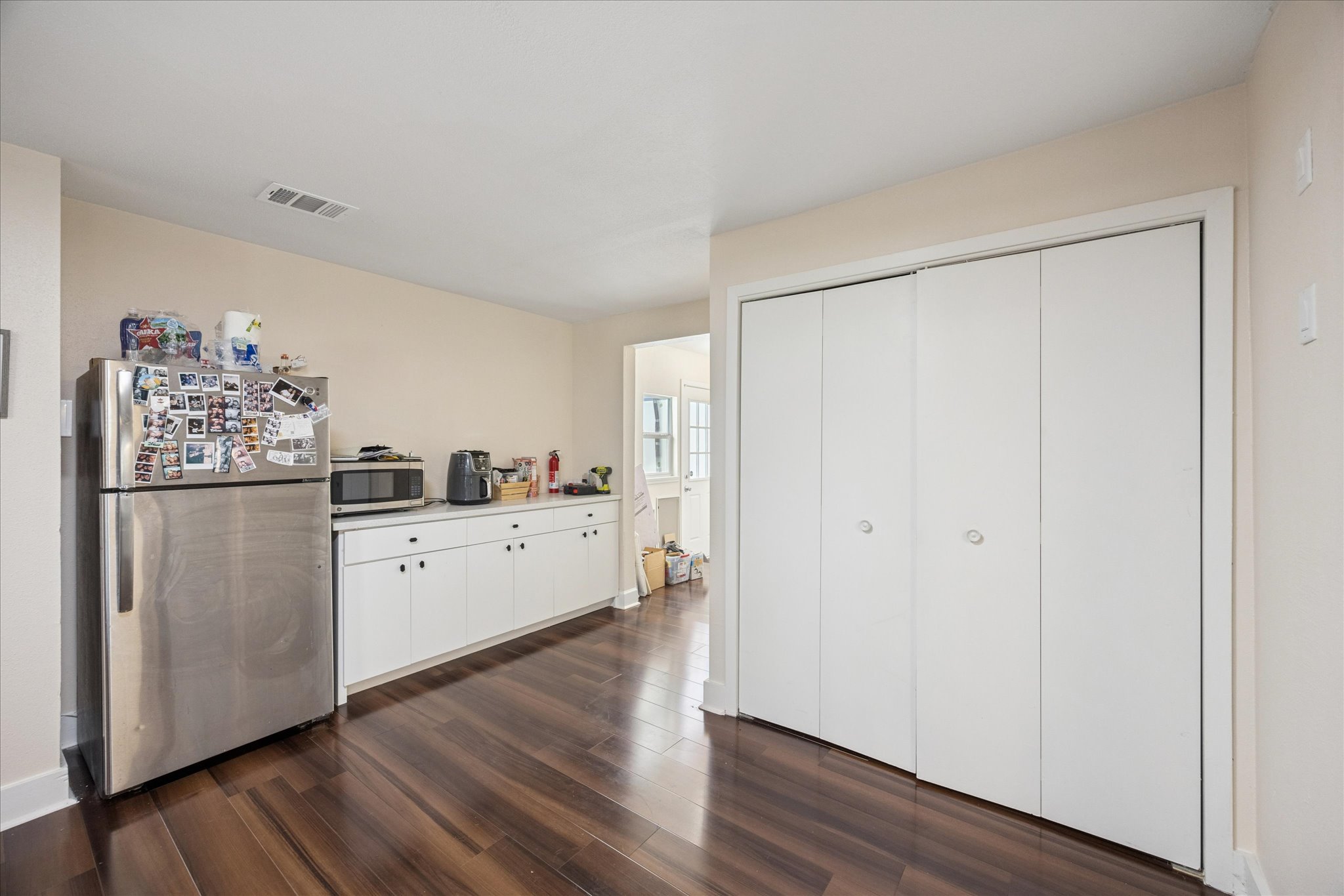 907 East 53rd Street Austin, TX 78751 - Photo 10 of 30 Kitchen with appliances with stainless steel finishes, white cabinets, dark wood finished floors, and light quartz countertops