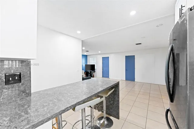 a kitchen with stainless steel appliances granite countertop a refrigerator a stove and a sink with granite countertops