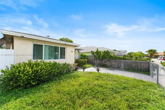 a view of a house with a yard and potted plants