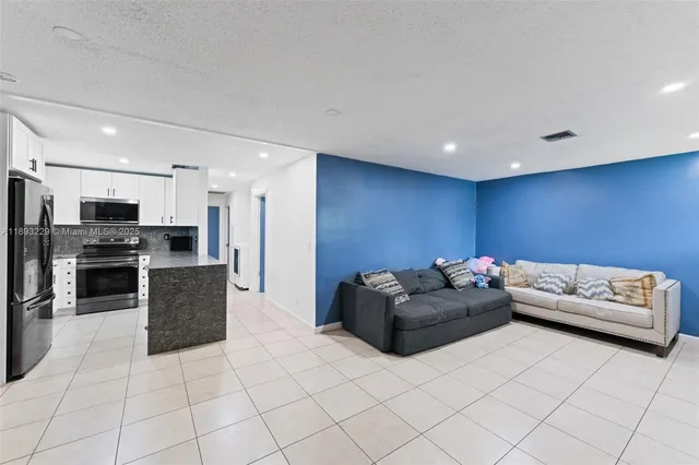 a living room with furniture and kitchen view