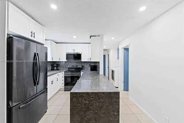a kitchen with stainless steel appliances a refrigerator sink and microwave