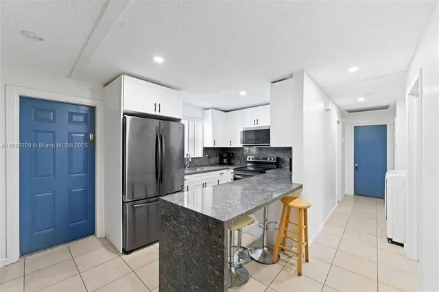a kitchen with stainless steel appliances granite countertop a refrigerator and a stove