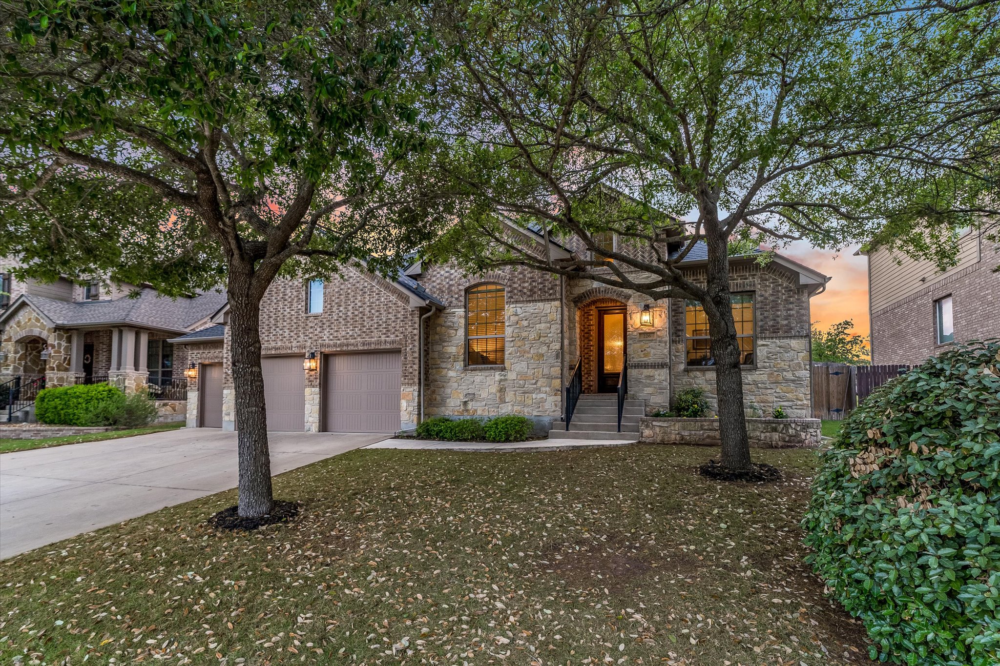 226 Galloway Lane Austin, TX 78737 - Photo 5 of 30 View of front of house with stone siding, concrete driveway, and an attached garage