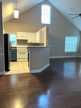 a view of a kitchen with wooden floor and a window