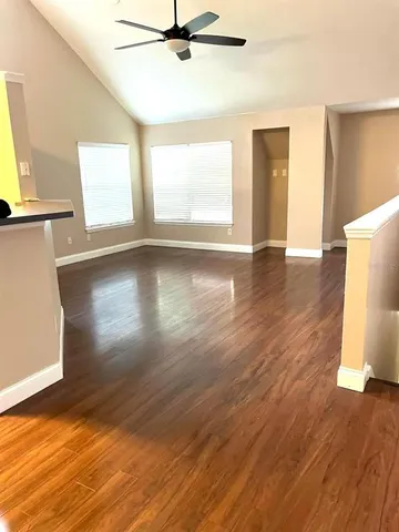 a view of a livingroom with wooden floor and a window