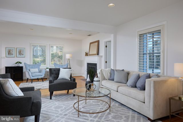 a living room with furniture a large window and a fireplace