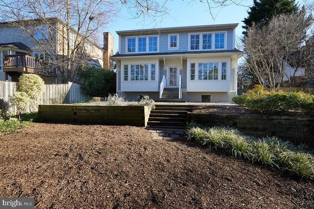 a view of a house with a yard and potted plants