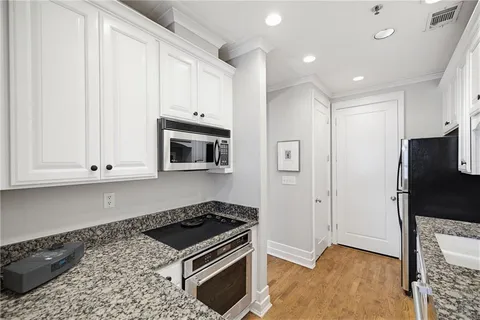 a kitchen with stainless steel appliances granite countertop a refrigerator and a stove top oven