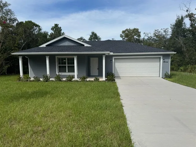 a front view of a house with a yard and trees