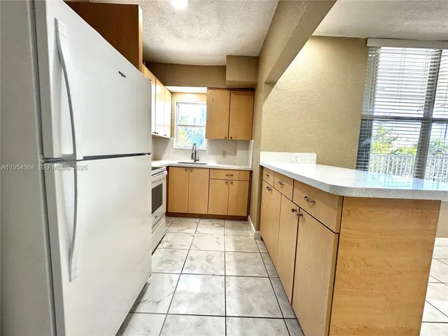 a kitchen with granite countertop cabinets stainless steel appliances and a sink