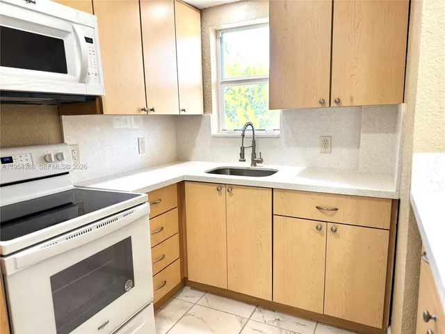 a kitchen with a sink cabinets and window