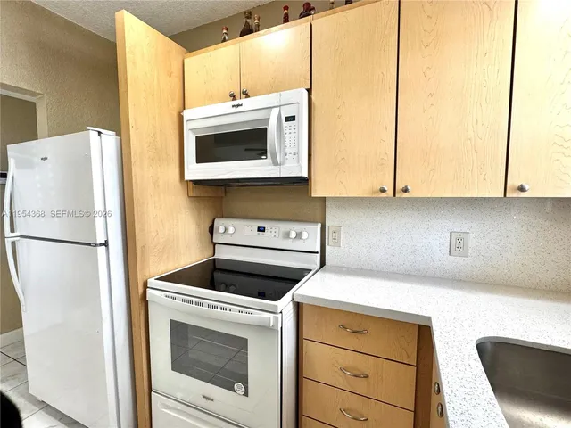 a kitchen with a sink a window and cabinets