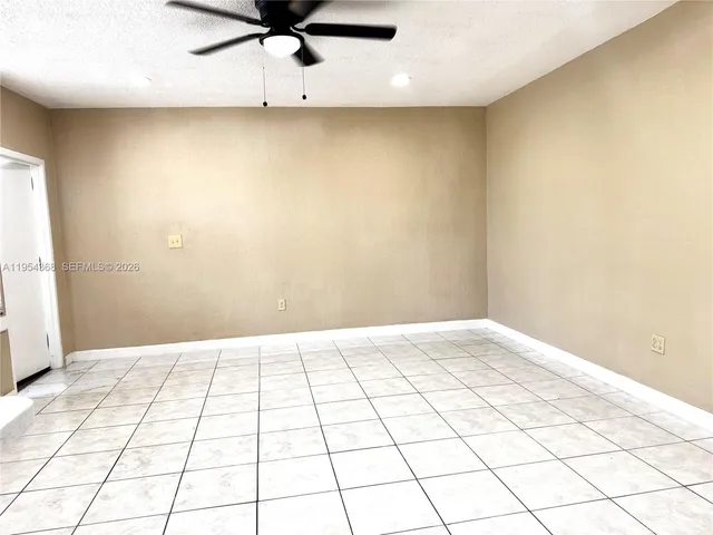 a view of kitchen and empty room with wooden floor