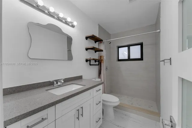 a bathroom with a toilet a sink and mirror