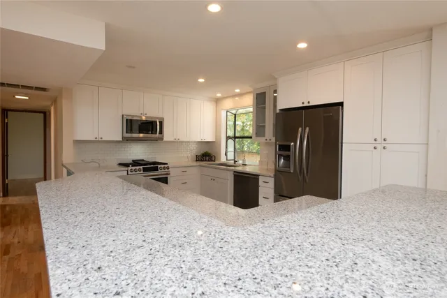 an empty room with kitchen and entrance door