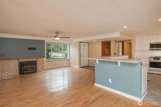 a view of empty room with wooden floor and fireplace