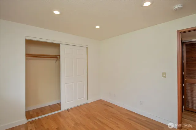 an empty room with wooden floor and a window