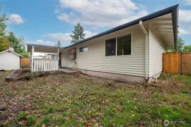 a view of a house with a large window and wooden fence