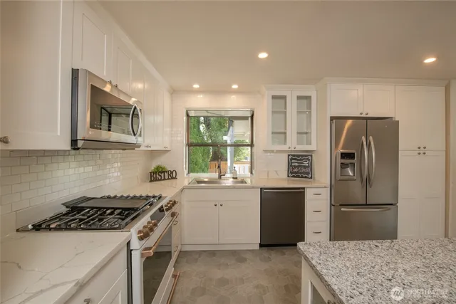 a kitchen with stainless steel appliances granite countertop a sink stove and refrigerator